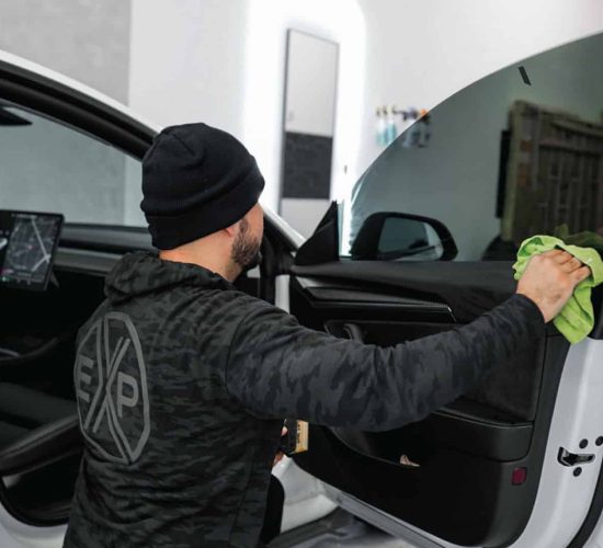 A TintBusiness employee tinting a Tesla front window in USA